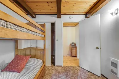 a bedroom with a bunk bed and a hallway at Cabin with Deck and Fire Pit in Blue Lake Springs! in Arnold