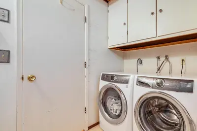 a washer and dryer in a white laundry room at Cabin with Deck and Fire Pit in Blue Lake Springs! in Arnold