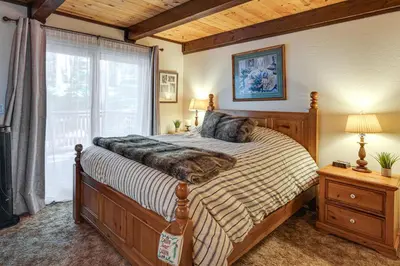 a bedroom with a large bed and a window at Cabin with Deck and Fire Pit in Blue Lake Springs! in Arnold