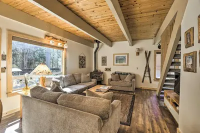 a living room with couches and a staircase at 3 Mi to Lake Tahoe Quiet Incline Village Cabin! in Incline Village
