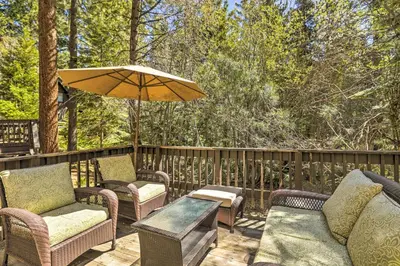 a patio with chairs and a table and an umbrella at 3 Mi to Lake Tahoe Quiet Incline Village Cabin! in Incline Village