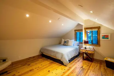 a bedroom with a bed and a table and two windows at 4 Mi to Diamond Peak Ski Resort Gem with Hot Tub in Incline Village