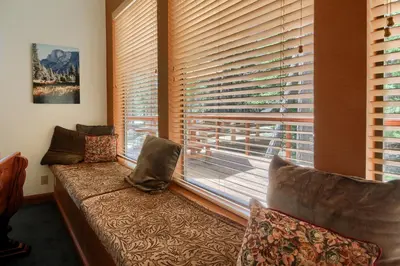 a living room with a couch and a large window at 92R Jolie Cabin in North Wawona