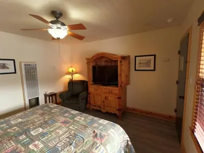 a bedroom with a bed and a flat screen tv at CREEKSIDE LODGE in Markleeville