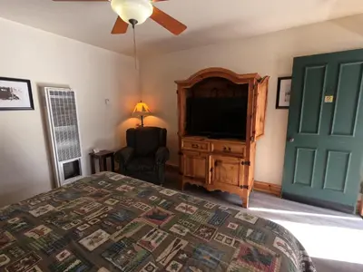 a bedroom with a bed and a flat screen tv at CREEKSIDE LODGE in Markleeville