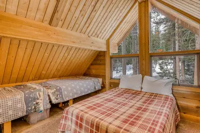 a bedroom with two beds in a log cabin at Soda Springs Surprise in Soda Springs