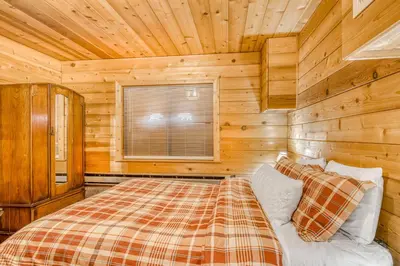 a bedroom with a bed in a log cabin at Soda Springs Surprise in Soda Springs
