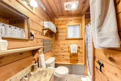 a log cabin bathroom with a toilet and a sink at Soda Springs Surprise in Soda Springs