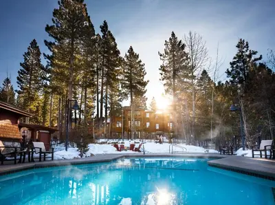 a swimming pool in the snow with a house in the background at Hyatt Vacation Club at High Sierra Lodge in Incline Village