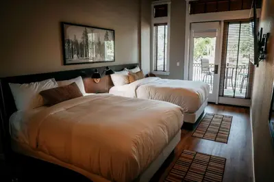 a bedroom with two beds and a balcony at Gateway Hotel, Trademark Collection by Wyndham in Copper Cove Subdivision