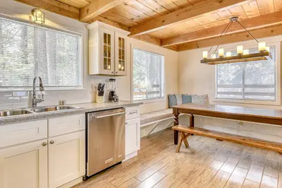a kitchen with white cabinets and a wooden ceiling at Flicker Retreat in Homewood