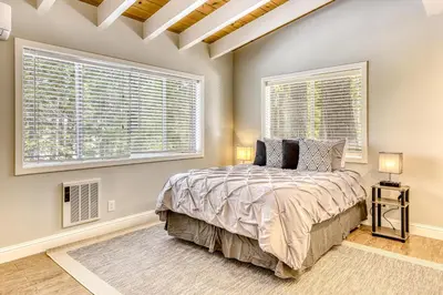 a bedroom with a large bed and two windows at Flicker Retreat in Homewood