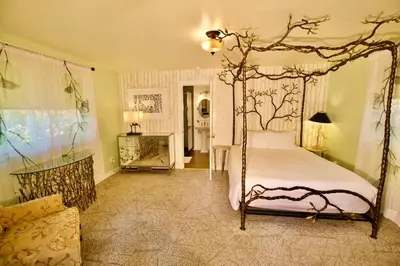 a bedroom with a canopy bed and a living room at Yosemite Bug Rustic Mountain Resort in Midpines