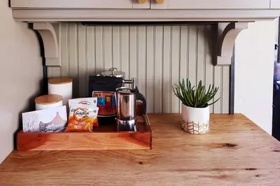 a wooden table with a coffee maker on top of it at Ski, Shop and Explore Walkable Midtown Reno Oasis! in Reno