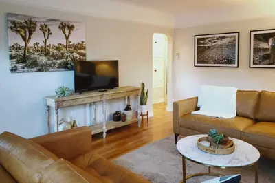 a living room with a couch and a television at Ski, Shop and Explore Walkable Midtown Reno Oasis! in Reno
