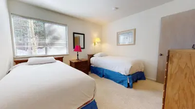a small bedroom with two beds and a window at Mammoth Estates 2 Bedroom Condos Near Mammoth Village in Mammoth Lakes
