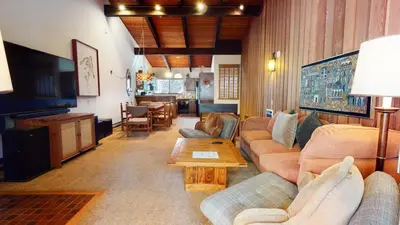 a living room with couches and a television and a table at Mammoth Estates Deluxe 2 Bedroom Condos in Mammoth Lakes