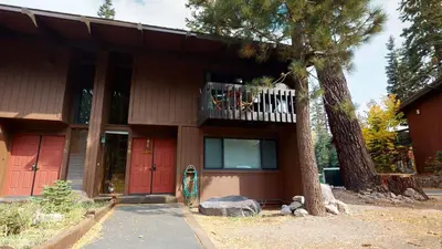 a house with red doors and a tree at Mammoth Estates 4 Bedroom Condos - Great for Families! in Mammoth Lakes