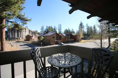 a table and chairs on a balcony with a view of a street at Mammoth Estates 4 Bedroom Condos - Great for Families! in Mammoth Lakes