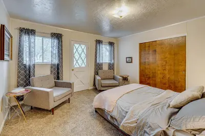 a bedroom with a bed and two chairs in it at Balcony and Forest Views Cabin in Pioneer! in Pioneer
