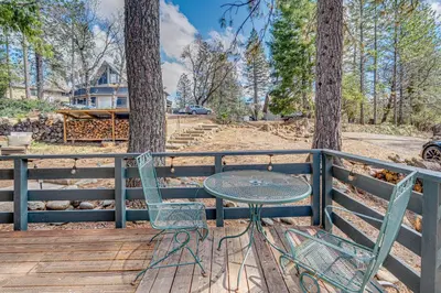 a table and two chairs sitting on a wooden deck at Balcony and Forest Views Cabin in Pioneer! in Pioneer