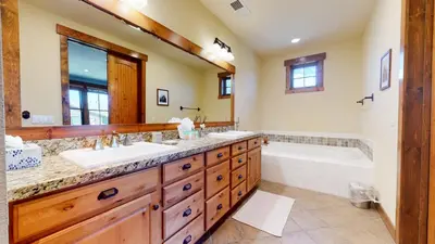 a bathroom with two sinks and a tub and a large mirror at Snowcreek The Lodges #1127 condo in Mammoth Lakes