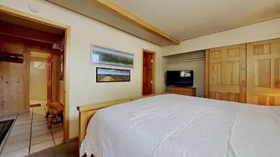 a bedroom with a white bed and a tv at 2 Bedroom Townhome With Easy Access to Mountain Biking & Lake Activities - Unit 531 at 1849 condo in Mammoth Lakes