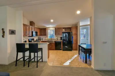 a kitchen with a table and chairs and a refrigerator at 3R Suter's Forte in North Wawona