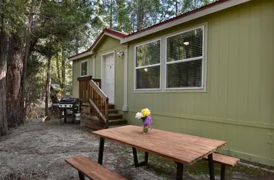 a vase of flowers on a picnic table in front of a house at 3R Suter's Forte in North Wawona
