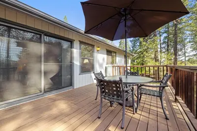 a patio with a table and chairs and an umbrella at Mountain Springs Lodge in Groveland