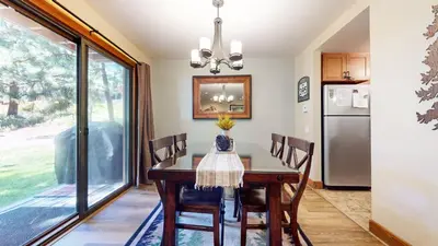 a dining room with a table and a refrigerator at Snowcreek #13 condo in Mammoth Lakes