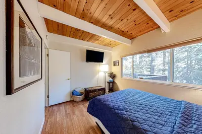 a bedroom with a blue bed and a large window at Echo Escape in South Lake Tahoe