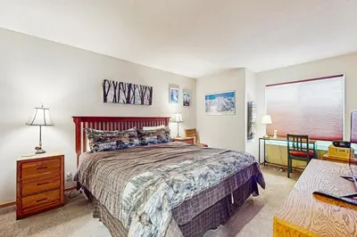 a bedroom with a bed and a desk and a window at Snowcreek 607 in Mammoth Lakes