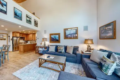 a living room with a blue couch and a table at Summit 70 in Mammoth Lakes