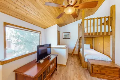 a living room with a tv and a bunk bed at Summit 70 in Mammoth Lakes