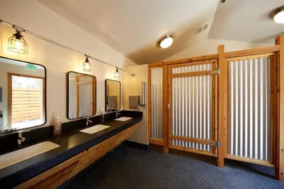 a bathroom with two sinks and two mirrors at Evergreen Lodge at Yosemite in Groveland
