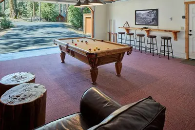 a pool table in a room with bar stools at Evergreen Lodge at Yosemite in Groveland