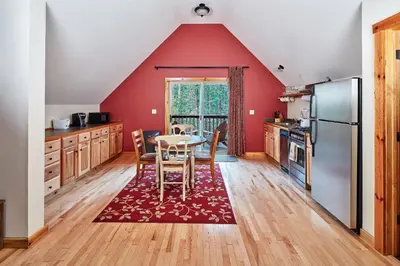 a kitchen with red walls and a table and chairs at Evergreen Lodge at Yosemite in Groveland