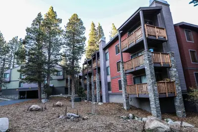 a apartment building with a balcony and trees at Summit #293 condo in Mammoth Lakes
