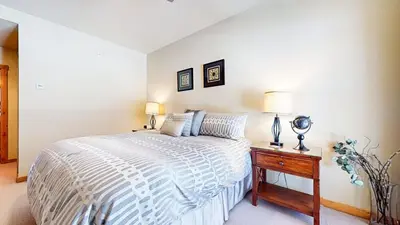 a bedroom with a bed and a table with a lamp at Solstice #18 condo in Mammoth Lakes