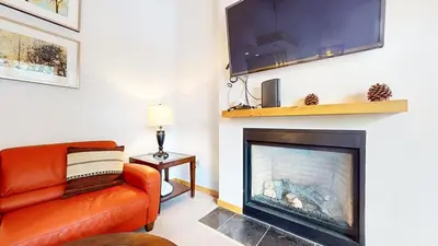 a living room with a orange couch and a fireplace at Solstice #18 condo in Mammoth Lakes