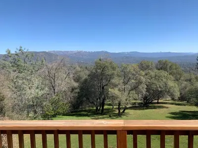 a view from a wooden bench overlooking a field of trees at Villa Alta Vista at Yosemite- Stunning Views and Game Room in Mariposa