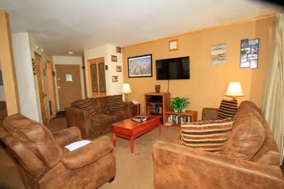 a living room with leather furniture and a flat screen tv at Sierra Park Villas 29 in Mammoth Lakes