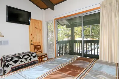 a bedroom with a bed and a balcony with a television at Sierra Park Villas 29 in Mammoth Lakes