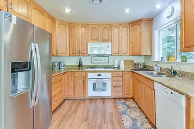 a kitchen with wooden cabinets and a stainless steel refrigerator at Gateway to Yosemite Group-Friendly Groveland Home in Groveland