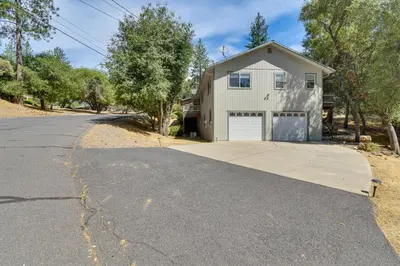 a house with a garage on the side of a road at Gateway to Yosemite Group-Friendly Groveland Home in Groveland