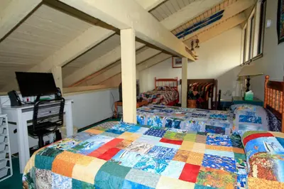 a bedroom with a quilt on a bed with a desk at Discovery 4 150 Loft in Mammoth Lakes