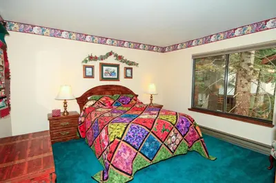 a bedroom with a bed with a colorful quilt at Discovery 4 150 Loft in Mammoth Lakes