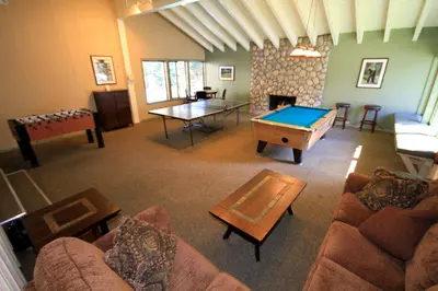 a living room with a ping pong table and a room with a pool table at Discovery 4 150 Loft in Mammoth Lakes