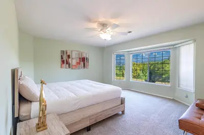 a bedroom with a bed with a ceiling fan and a window at Spectacular Views w/ Hot Tub/BBQ -Yosemite & Bass Lake in Oakhurst